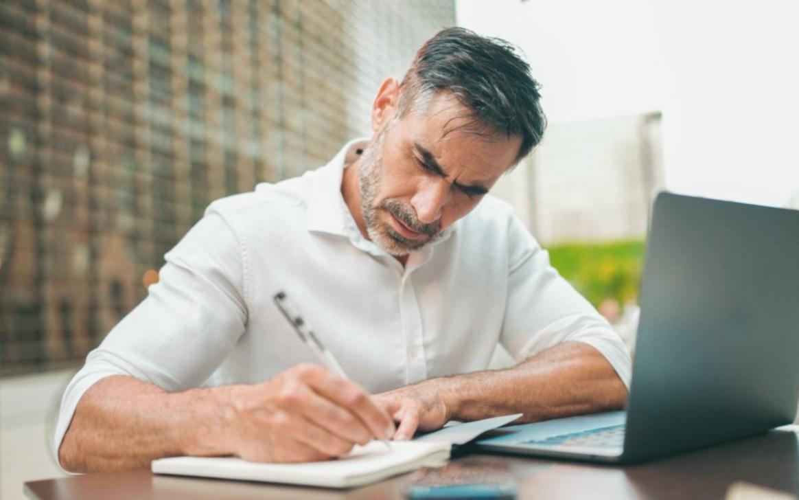 Espace de travail collaboratif avec documents financiers et ordinateurs lors d'une session de formation